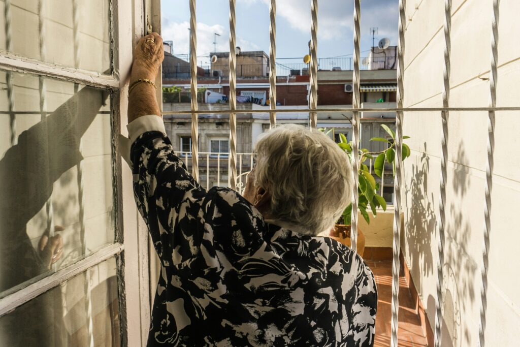 Caregiver assisting elderly man during home safety inspection in living room