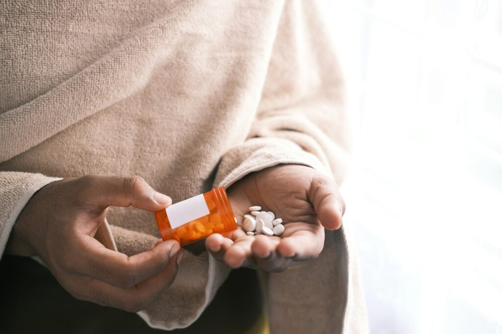 Close-up of hands holding a weekly medication organizer.