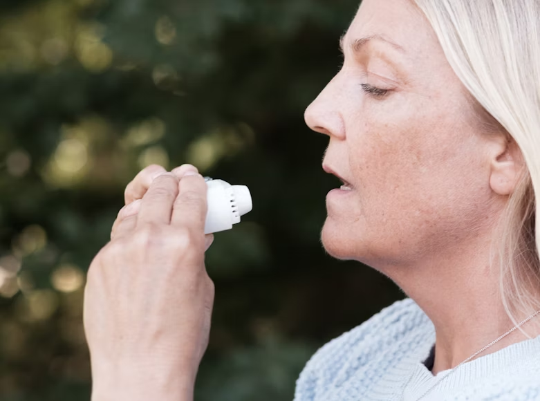 Senior using mouth freshener with a smile, maintaining oral hygiene and fresh breath.