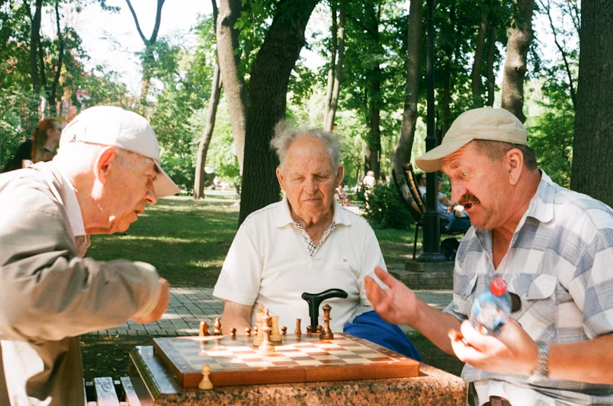 Happy seniors playing chess at a care center