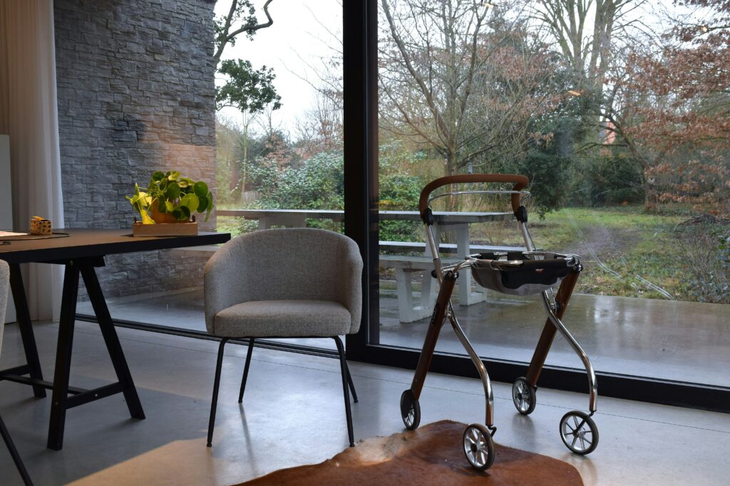 Caregiver helping elderly man walk safely at home while aging in place in Indiana