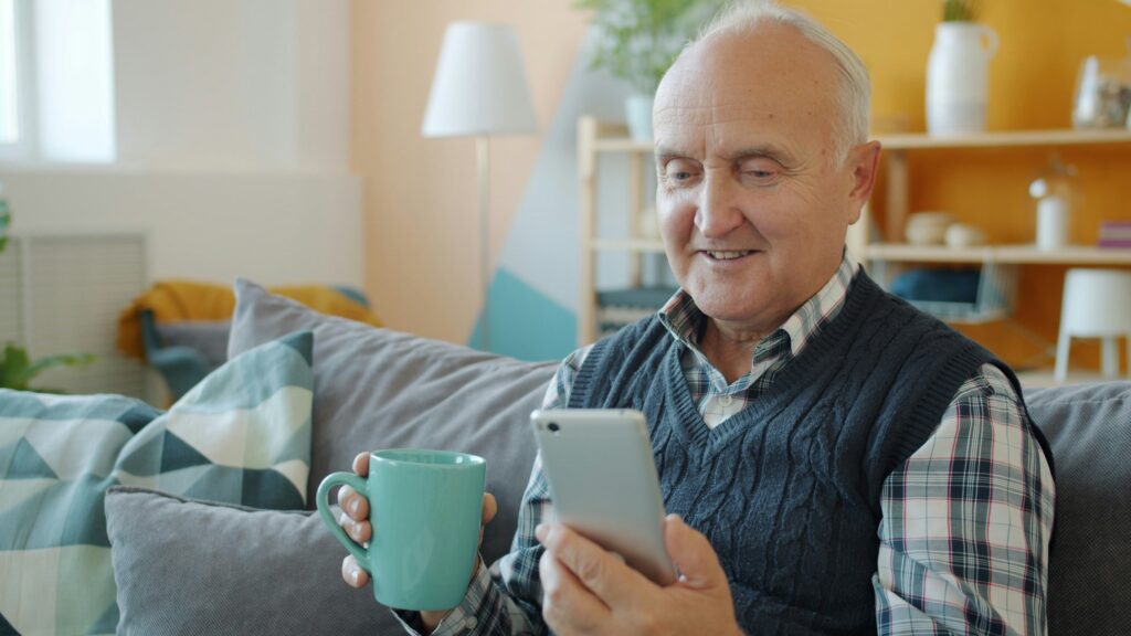 Elderly woman sipping herbal tea with caregiver during in-home hydration check