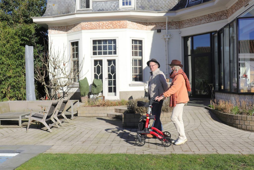 Senior couple waving from their front yard, showing the value of friendly neighbors nearby