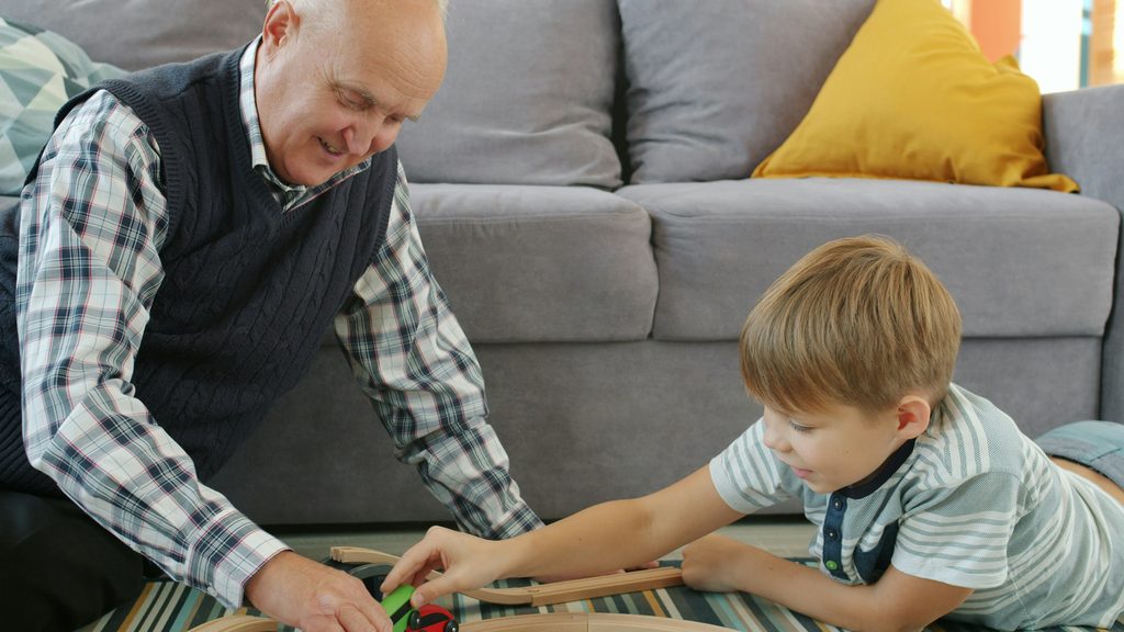 Senior man and companion caregiver playing chess at a kitchen table in an Indianapolis home