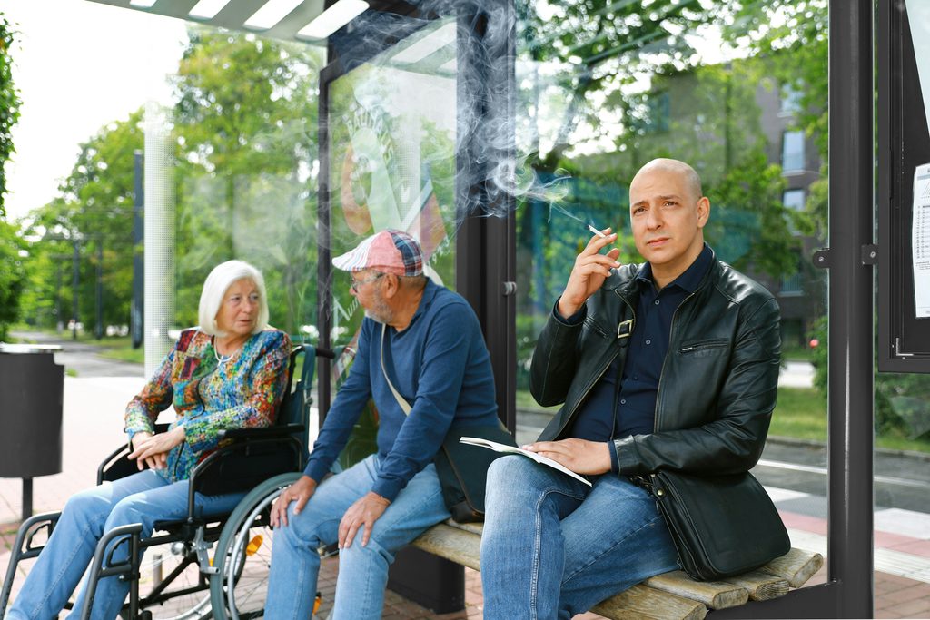 Group of older adults chatting outside a church after Sunday service as a caregiver helps one friend into a waiting car