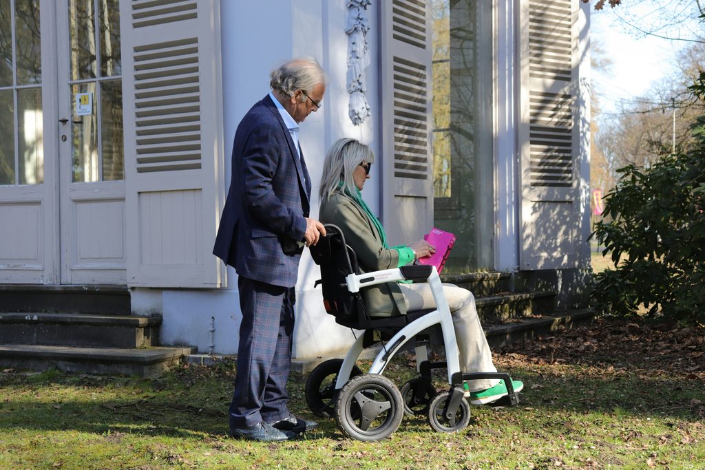Senior woman walking alone on a neighborhood sidewalk, living independently while family lives out of state